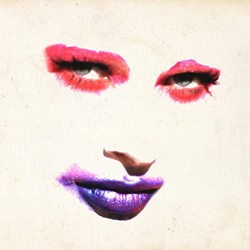 Close-up of a face with vibrant red and purple makeup, eyes and lips.