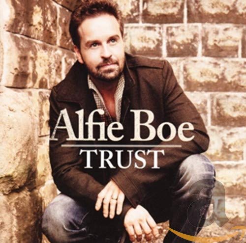 Alfie Boe posing against a stone wall for his Trust album cover.