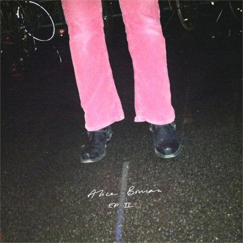 Pink pants and black boots on a dark, grainy street.