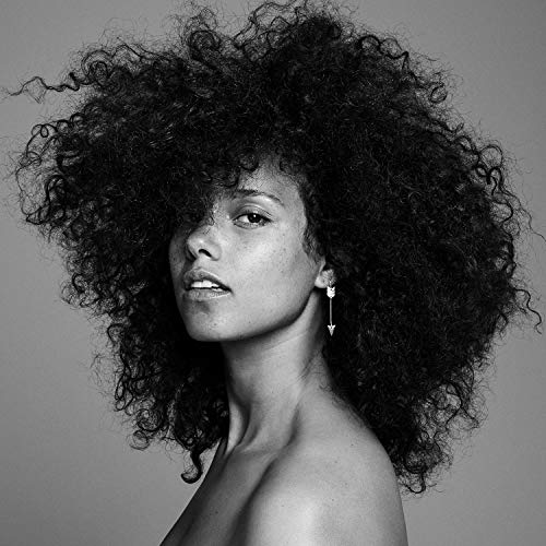 A black and white portrait of a woman with curly hair and a bare shoulder.