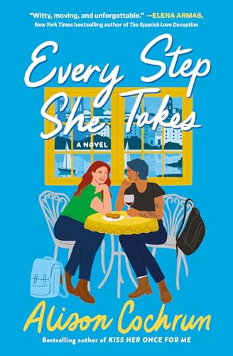 Two women sit at a cafe table in front of a window on a book.