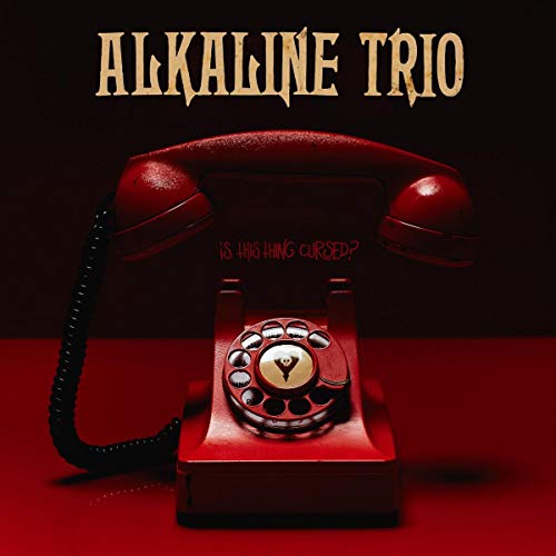 A red rotary telephone sits on a red surface against a dark background.