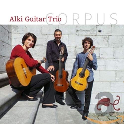 Alki Guitar Trio posing with classical guitars against a stone wall.