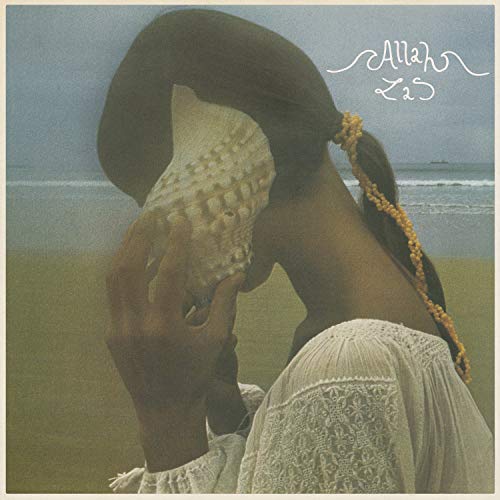 Album cover: woman holding a seashell at the beach.