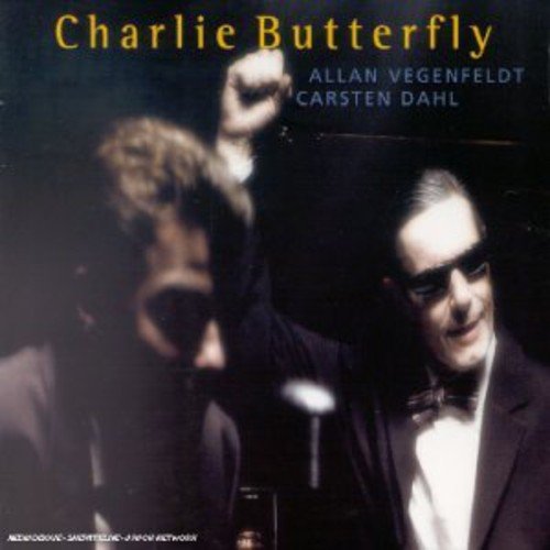 "CD cover featuring two men, one with raised fist, against a dark background."