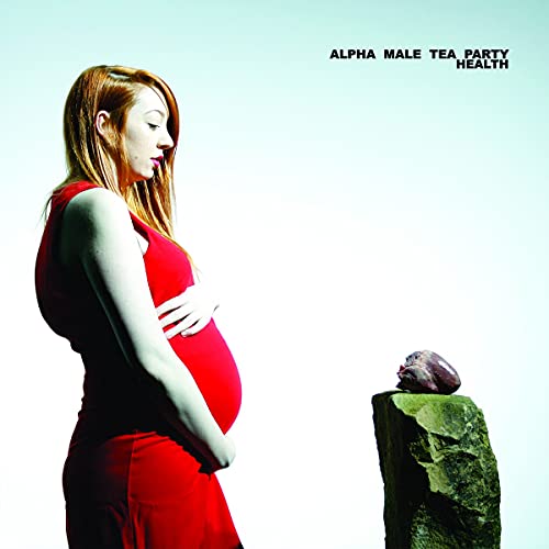 A pregnant woman in a red dress looking at a heart on a stone.