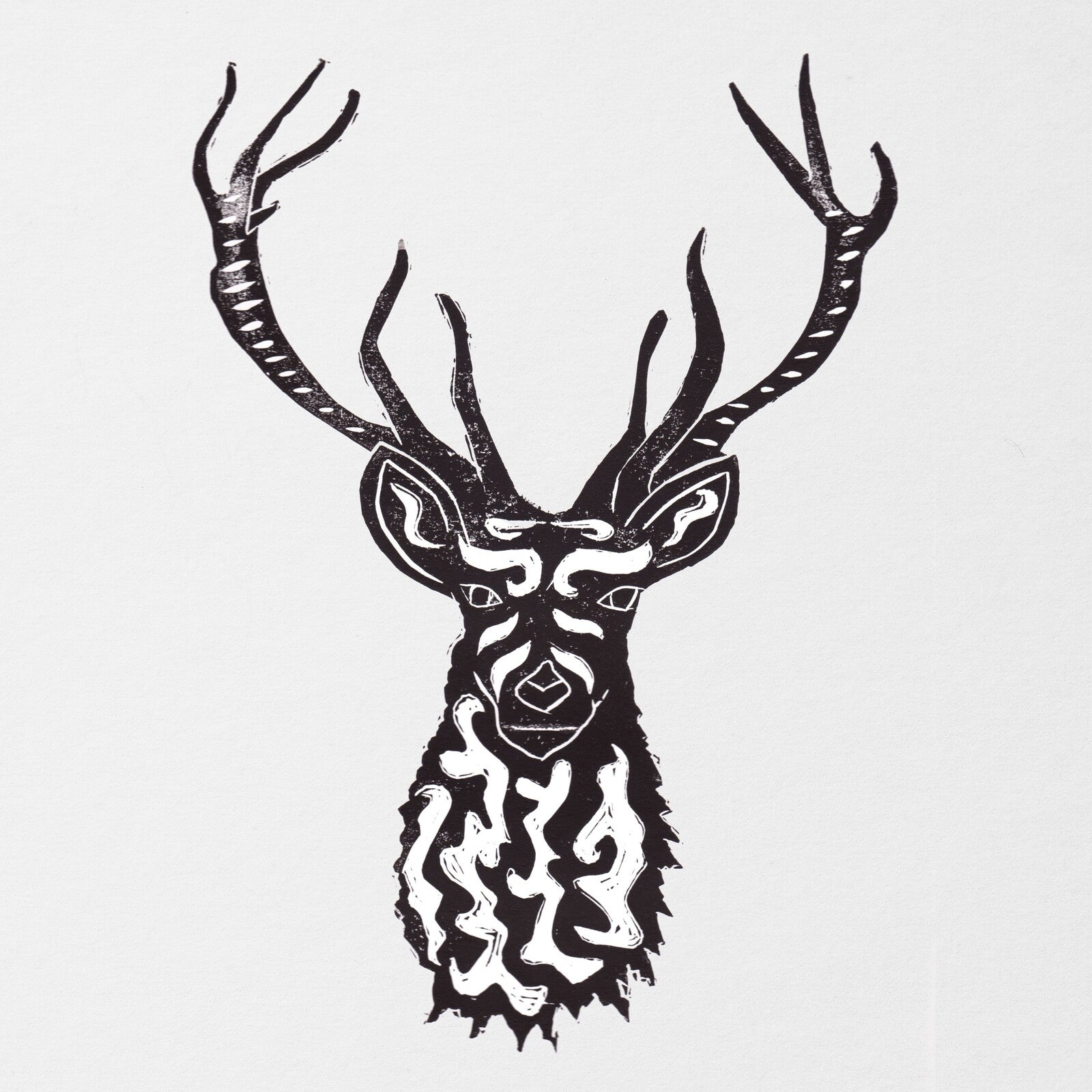 Black and white linocut print of a stylized deer head with intricate patterns.