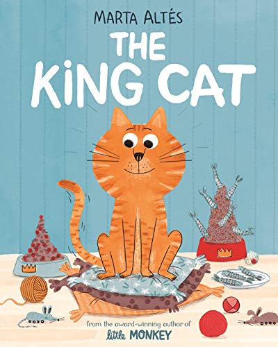 Orange striped cat sits on cushions, surrounded by toys and food.