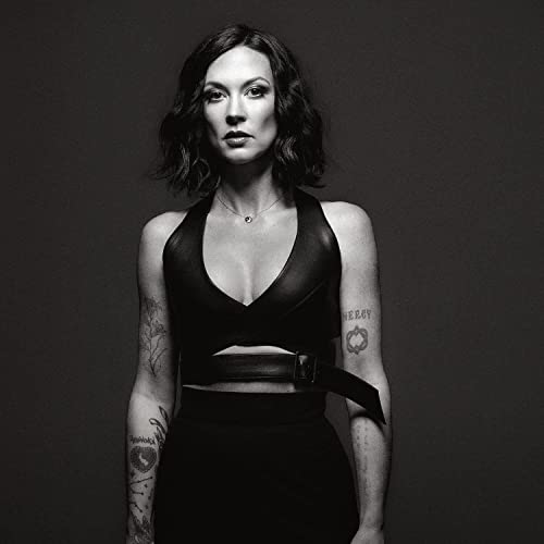 Black and white portrait of Amanda Shires wearing a black top against dark background.