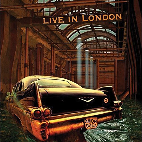 "Album cover featuring a rusted vintage car in a dimly lit, industrial setting."