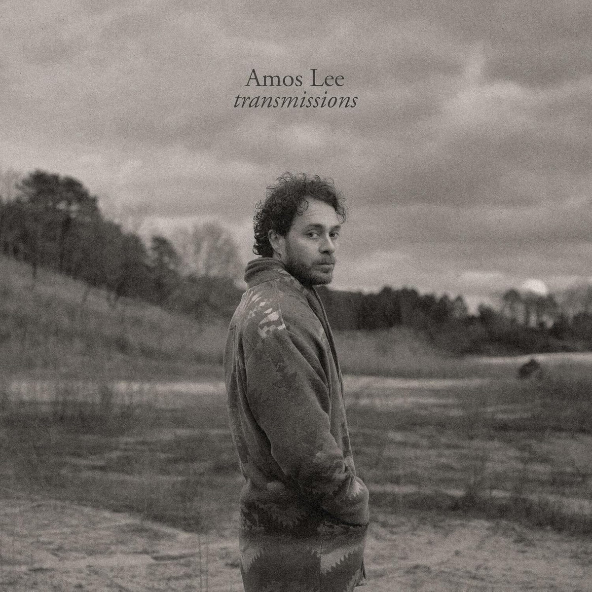 Black and white album cover featuring Amos Lee in a patterned jacket.