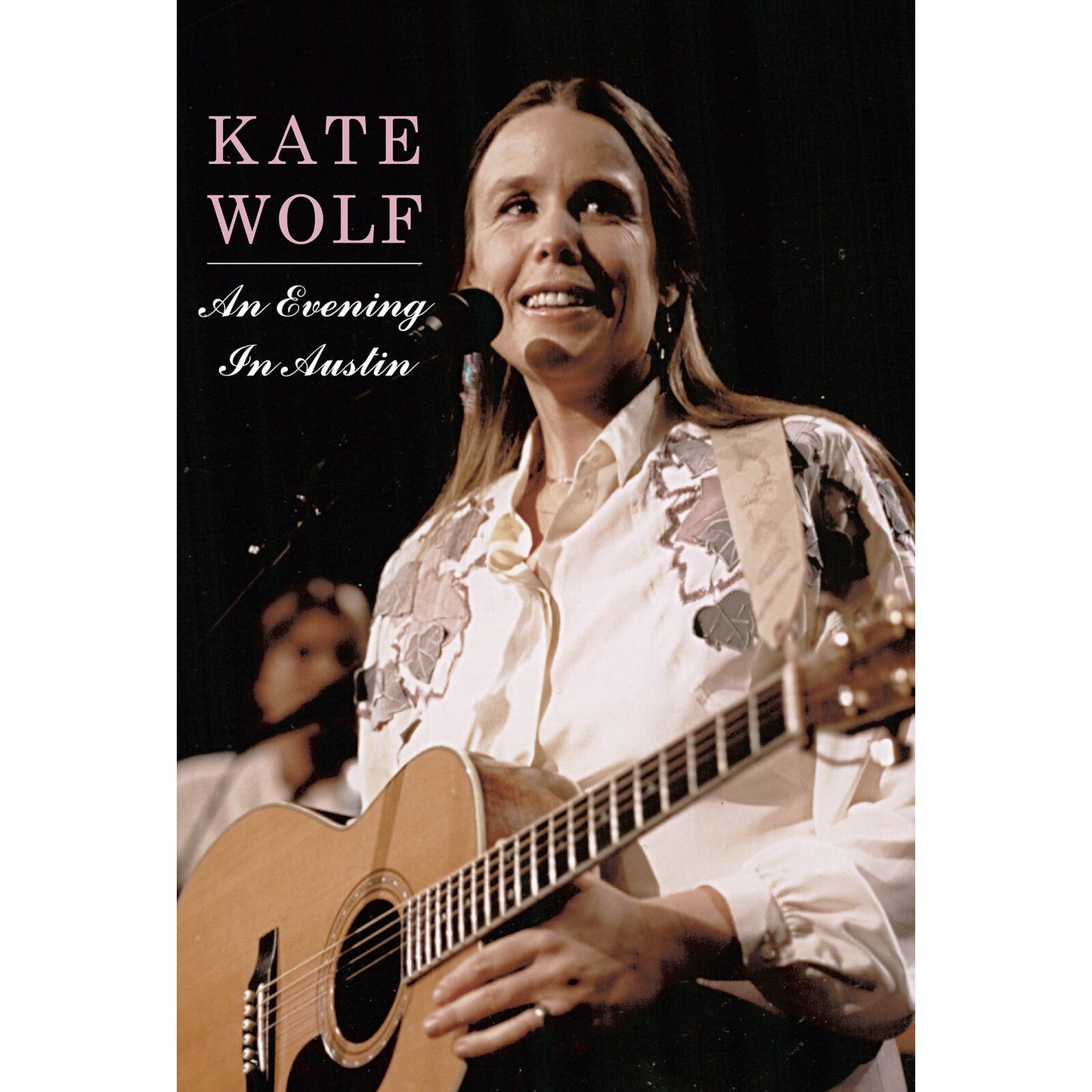 Kate Wolf on DVD cover, playing acoustic guitar onstage.