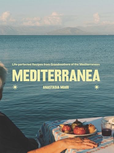 Book cover showing a person's hand at a table with food overlooking the sea.