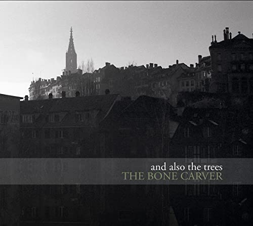 Black and white cityscape with album title "The Bone Carver" overlaid.
