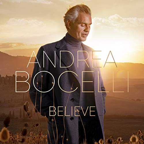 Andrea Bocelli in a coat standing in a field at sunset with album text.