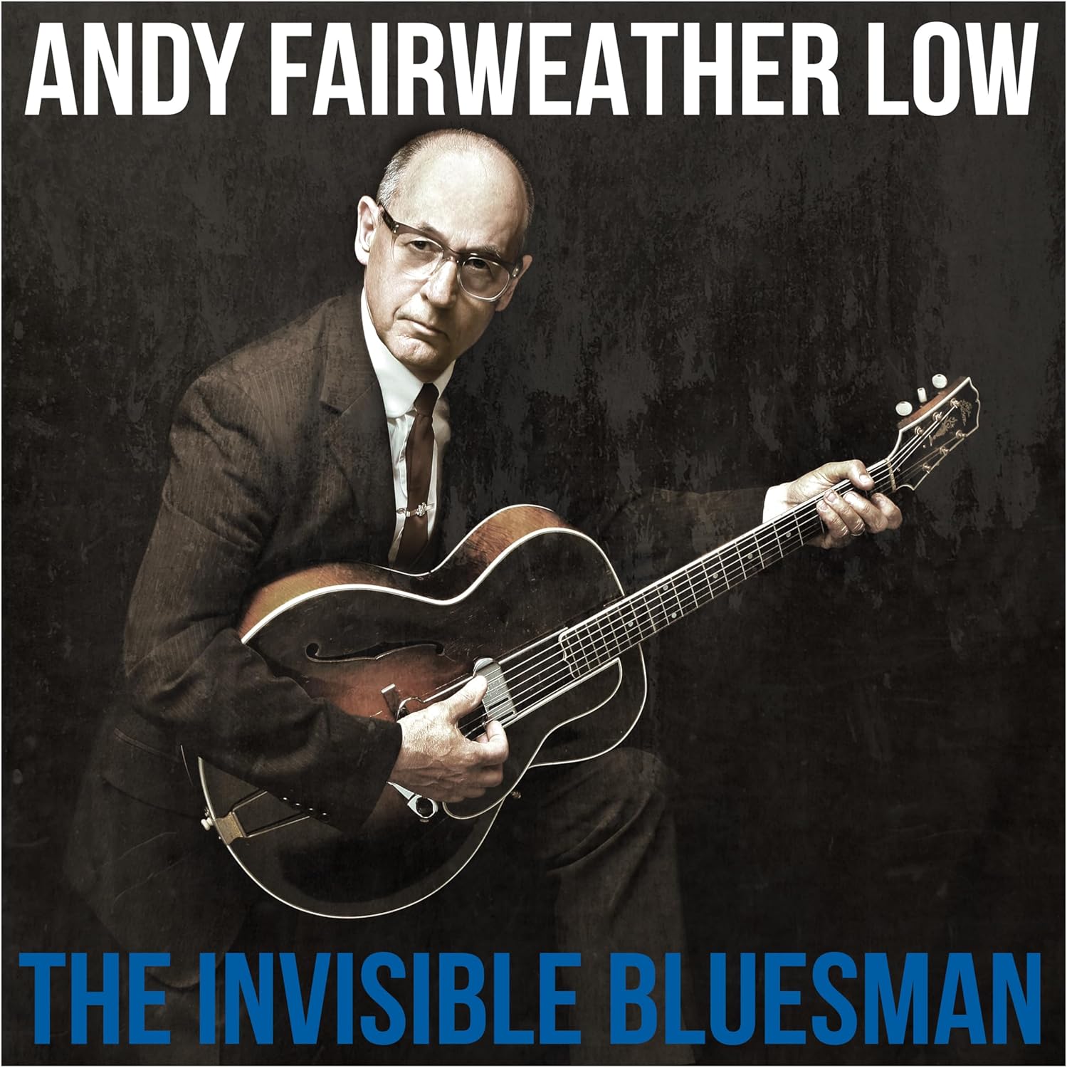 Andy Fairweather Low, suited, playing an electric guitar on album cover.