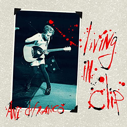 Ani DiFranco performing on stage in a photo frame with red text overlay.