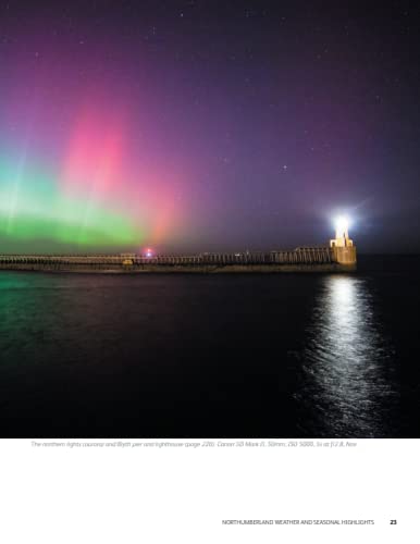 Northumberland coast lighthouse under vibrant green and pink aurora borealis.