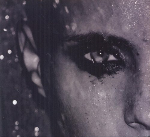 Close-up of a person’s eye with dark makeup and glittery background.
