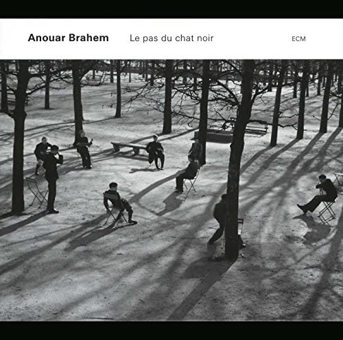 Black and white album cover with people in a sparse, tree-lined park.
