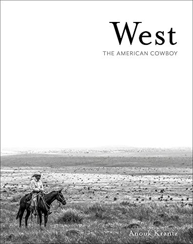 Black and white photo of a cowboy on horseback in a vast landscape.