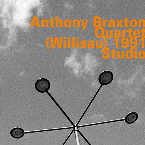 "Album cover with orange text and a black metal sculpture against a cloudy sky."