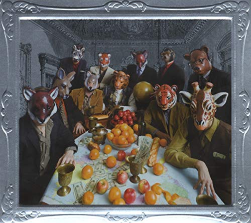 People wearing animal masks seated around a table with fruit and money.