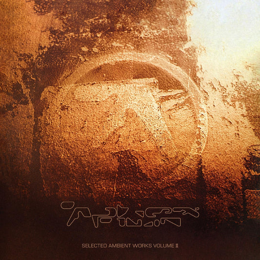 Album cover with a textured, golden-brown surface featuring the Aphex Twin logo.
