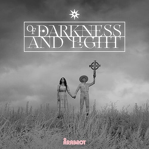 Black and white album cover with figures holding a cross in a field.