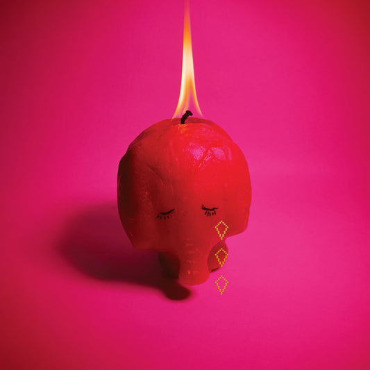 Burning pink elephant sculpture with closed eyes against a pink background.