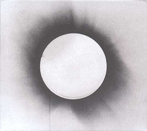 A bright white circle centered against a dark, hazy, charcoal-like background.