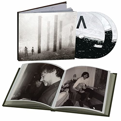 Open CD case with photos of people and abstract stone structures.