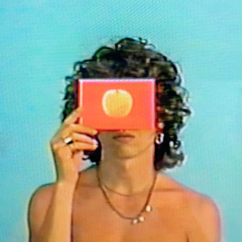 Person with curly hair holding a red square with a yellow circle.