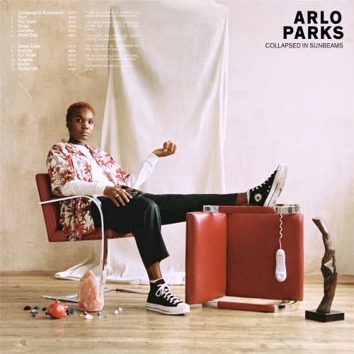 Arlo Parks album cover: woman seated in red chair, warm tones.