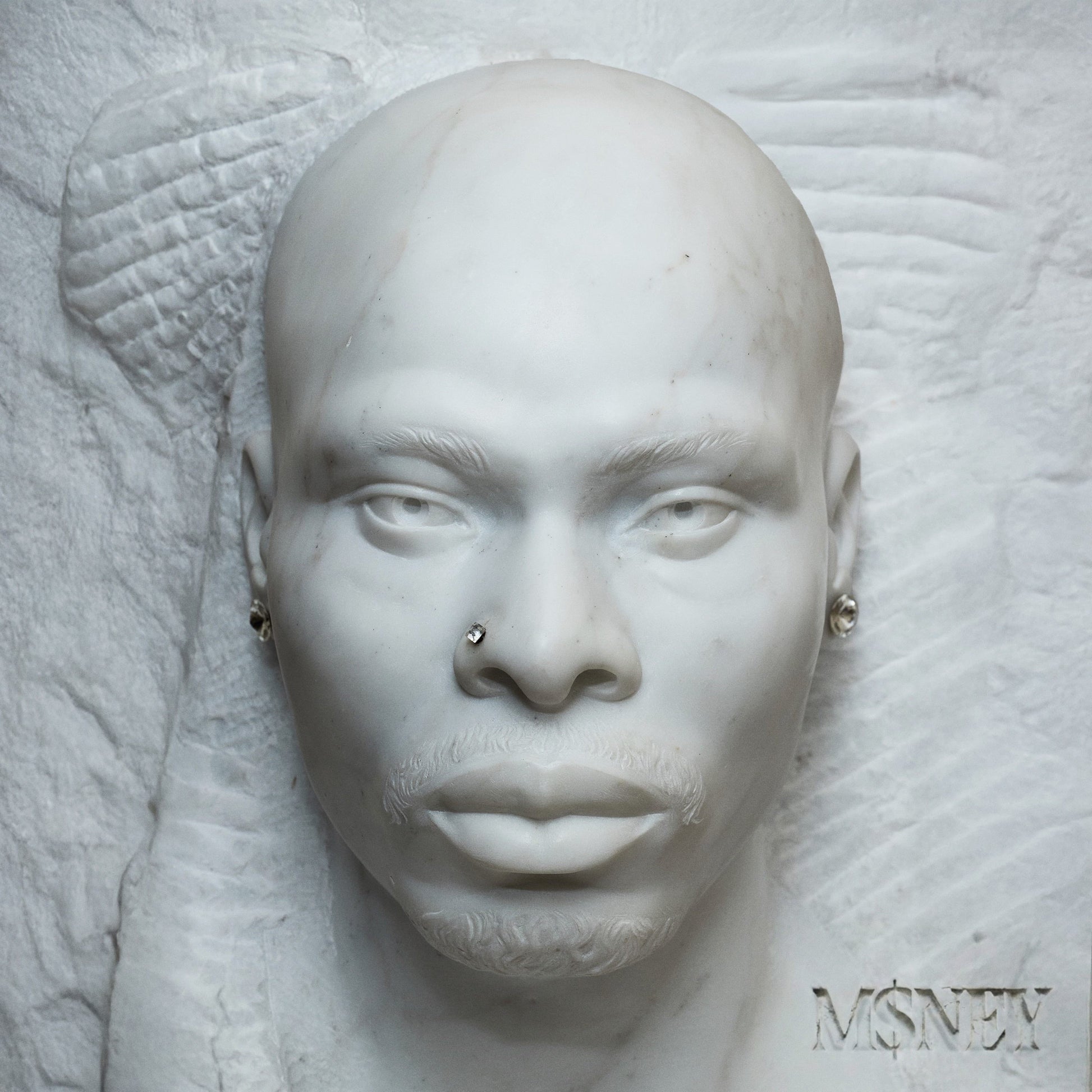 White marble sculpture of a man's face with nose and ear studs.