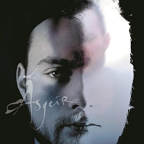 Close-up portrait of a man with half his face blurred, album artwork.