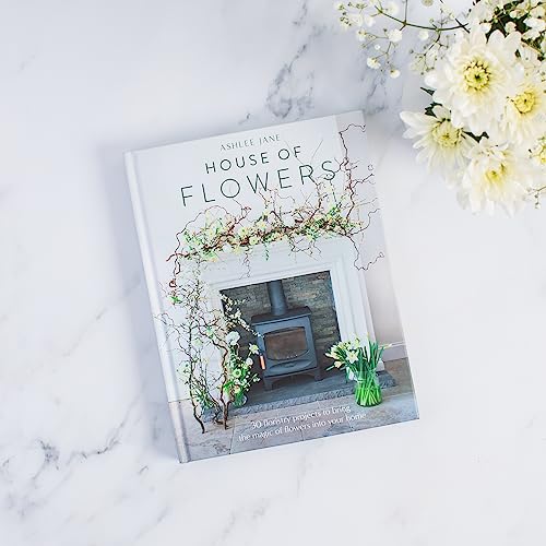 Book cover, “House of Flowers,” with floral imagery and a fireplace scene.