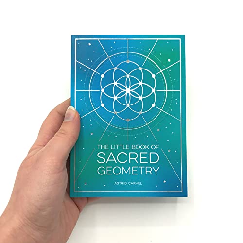 A hand holds a teal book titled The Little Book of Sacred Geometry.