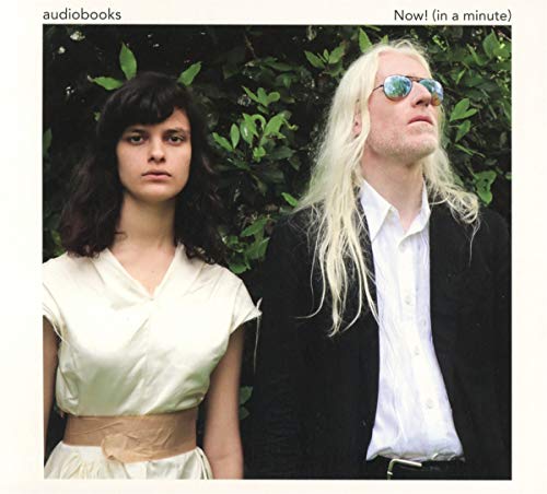 "Album cover featuring a man and woman standing together against a leafy green background."
