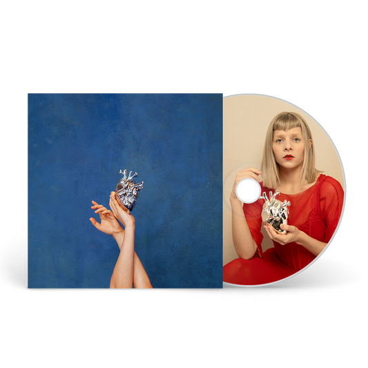 CD cover featuring hands holding a metallic heart against blue, with disc showing Aurora.