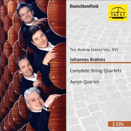 CD cover with four men in black suits, smiling, on a wooden background.