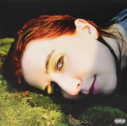 Austra album cover: close-up of a woman lying in green moss.