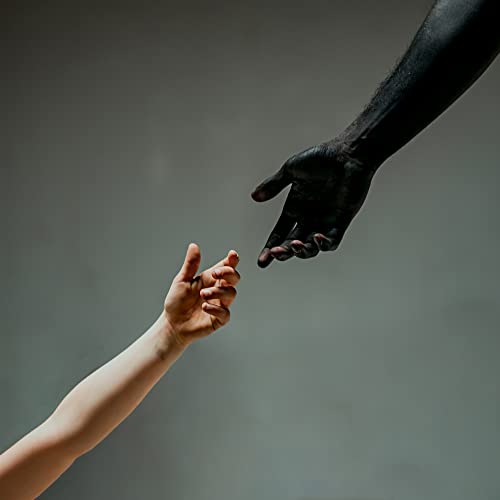 Two hands reaching for each other, contrasting skin tones, gray background.