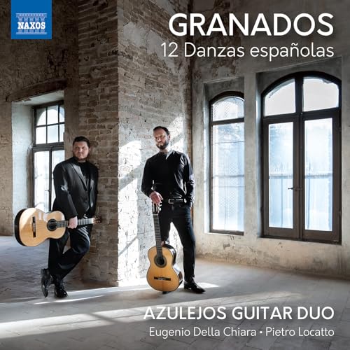 Two guitarists with instruments, standing in front of arched windows.