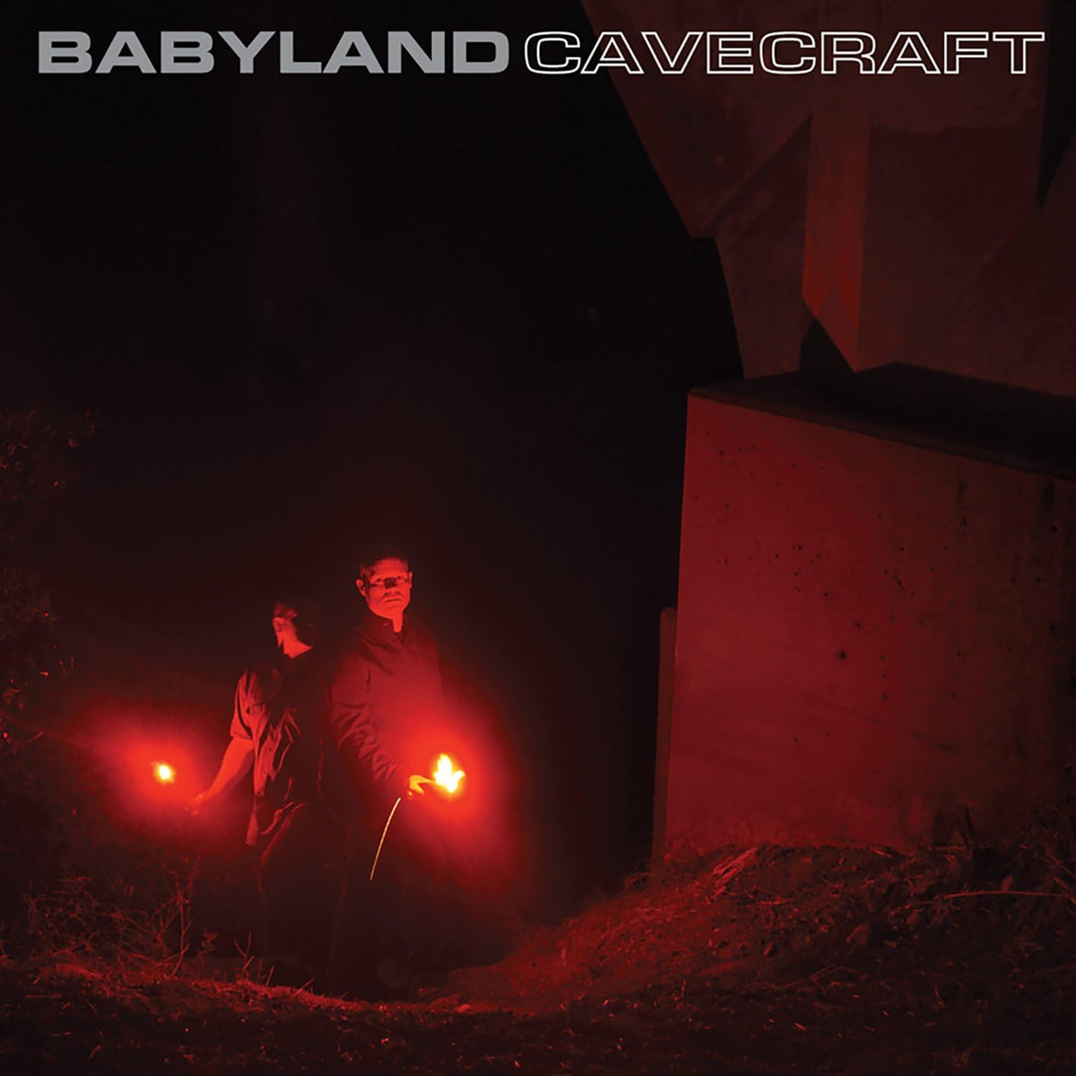 CD cover: two figures with lights stand before a dark building.