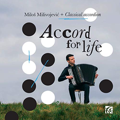 Man playing accordion in a field, surrounded by black and white circles.