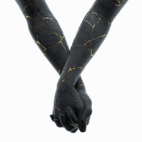 Black arms with golden cracks meeting in clasped hands, white background.