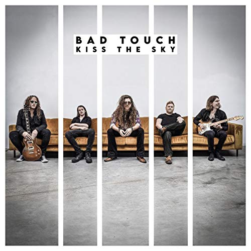"Album cover featuring four men sitting on a couch, with guitars."