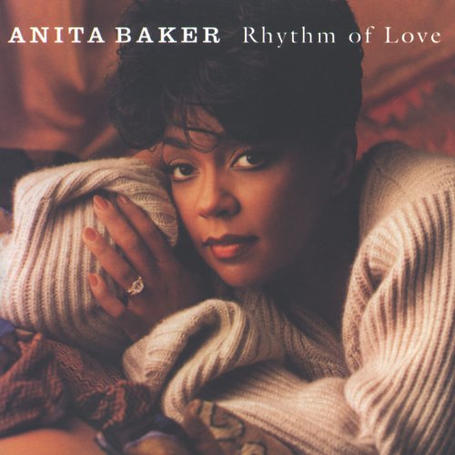 Anita Baker wearing a cream sweater, resting her head on her hand.