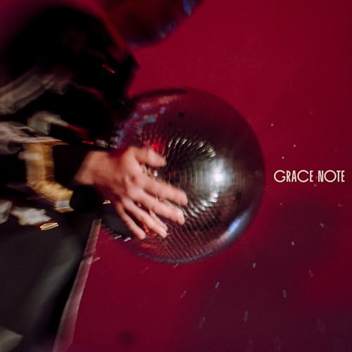 Hand touching a disco ball against a red background, album cover.